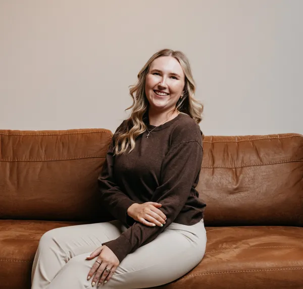 Savana McElwain, doula, seated on a leather couch